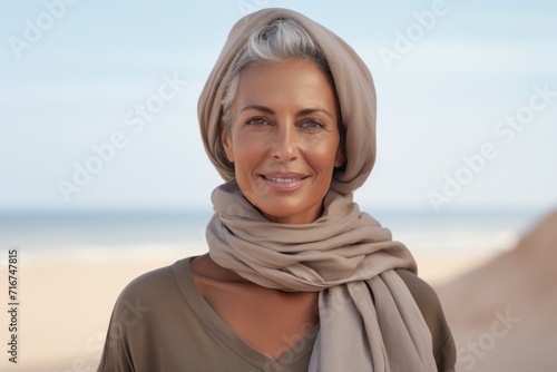 Portrait of a satisfied woman in her 50s wearing a versatile buff against a sandy beach background. AI Generation