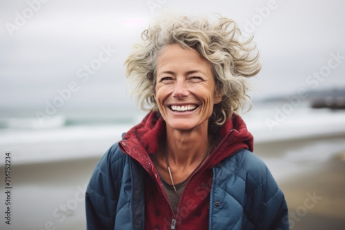 Portrait of a grinning woman in her 50s wearing a thermal fleece pullover against a crashing waves background. AI Generation