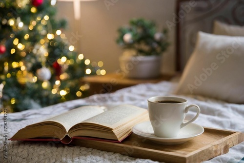 Coffee cup and an open book inside a holiday decorated home in a bed room