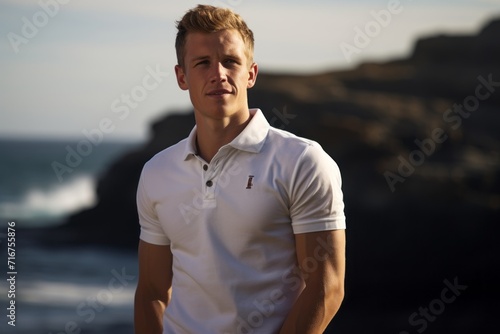 Portrait of a blissful man in his 20s wearing a breathable golf polo against a rocky shoreline background. AI Generation