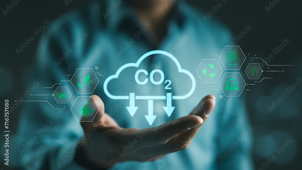 Carbon footprint concept. Man hand holding carbon reduction icon. Net zero and carbon neutral, Carbon emissions, CO2 neutrality, Sustainable energy, Climate change, Global warming, Greenhouse gas, - obrazy, fototapety, plakaty 