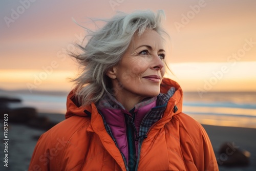 Portrait of a merry woman in her 50s sporting a quilted insulated jacket against a vibrant beach sunset background. AI Generation