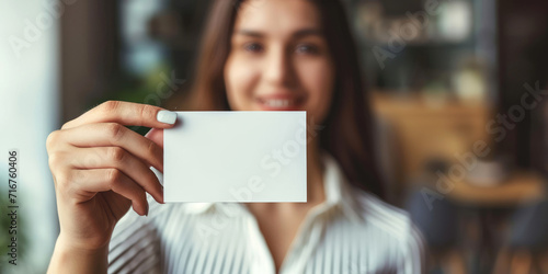 A young woman holding a blank business card