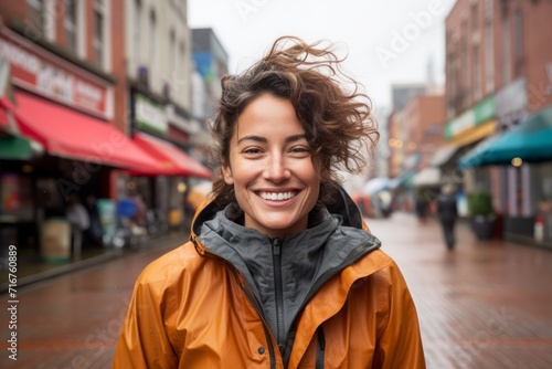 Portrait of a joyful woman in her 30s wearing a functional windbreaker against a vibrant market street background. AI Generation © CogniLens