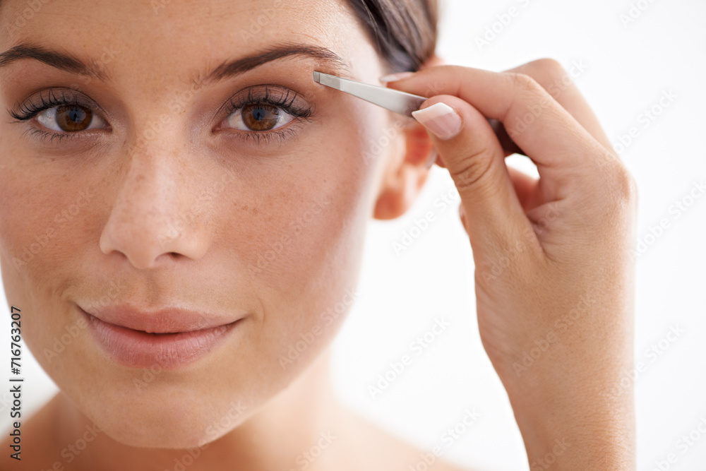 Woman, portrait and plucking eyebrow with tweezers for beauty and self care in bathroom. Makeup, routine and girl with hair removal, tools and facial grooming or cleaning for skincare and cosmetics