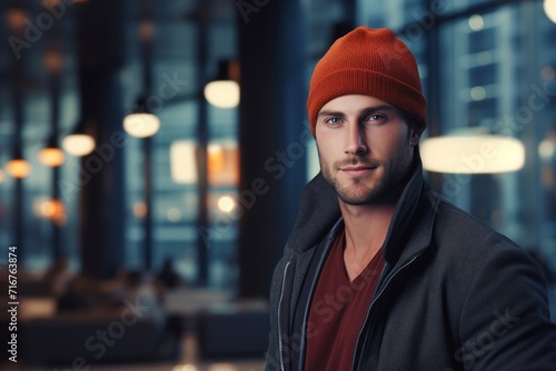 Portrait of a blissful man in his 30s dressed in a warm ski hat against a sophisticated corporate office background. AI Generation