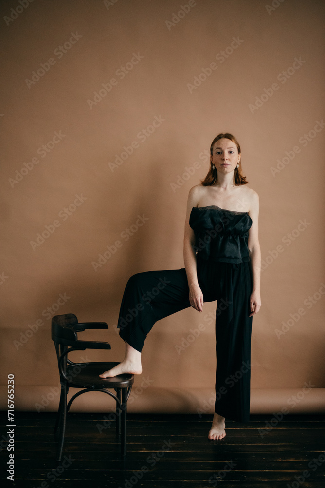 Fototapeta premium red-haired girl and black vintage chair