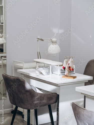 Nail salon bright interior. View of modern manicure shop. Inside beauty studio with white design. Clean empty trendy nail salon.