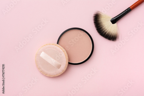 Mineral compact powder, make-up brush and sponge, isolated on a pink background photo