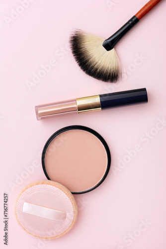 Mineral compact powder, make-up brush and sponge, isolated on a pink background