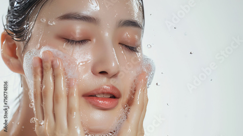Woman washing face enjoying a refreshing water splash in a spa, radiating beauty and wellness Facial care with a bright smile, Water droplets on the face, close-up of the face Banner for ads.