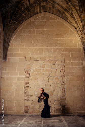 Chica joven rubia con traje flamenco posando en antiguo monasterio photo