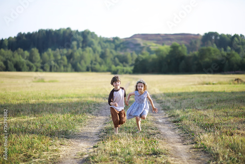 Children walk in the summer in nature. Child on a sunny spring morning in the park. Traveling with children. © alexkich