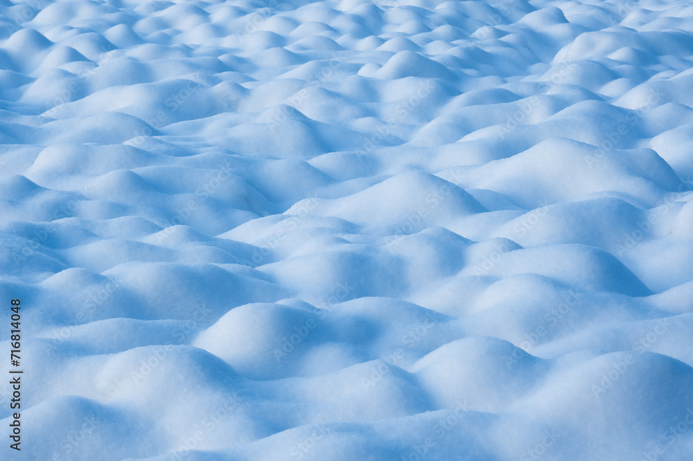 Abstract winter background from blue snow waves on snowy field Abstract winter background from blue snow waves on snowy field