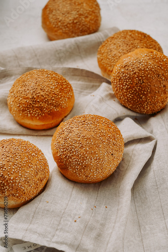 round buns with sesame seeds for a hamburger on a light background, without people