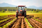 A farmer driving a tractor in a field, preparing the soil for planting crops on a sunny day.