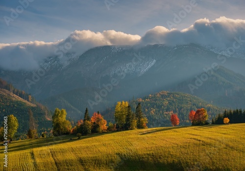 Beautiful autumn landscape in the mountains. Clouds illuminated by the morning sun floating low over the valley. Country panorama view from Slowakian High Tatras.