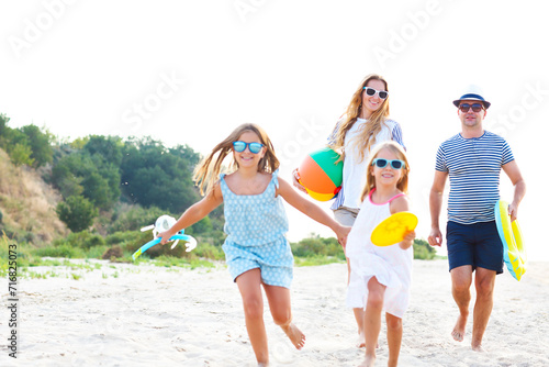 Family with children running at the beach
