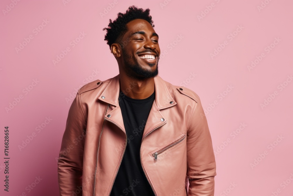 Fototapeta premium Portrait of a glad afro-american man in his 20s sporting a classic leather jacket against a pastel or soft colors background. AI Generation