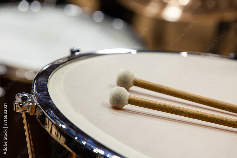 Drumsticks lie on timpani close-up Drumsticks lie on timpani close-up