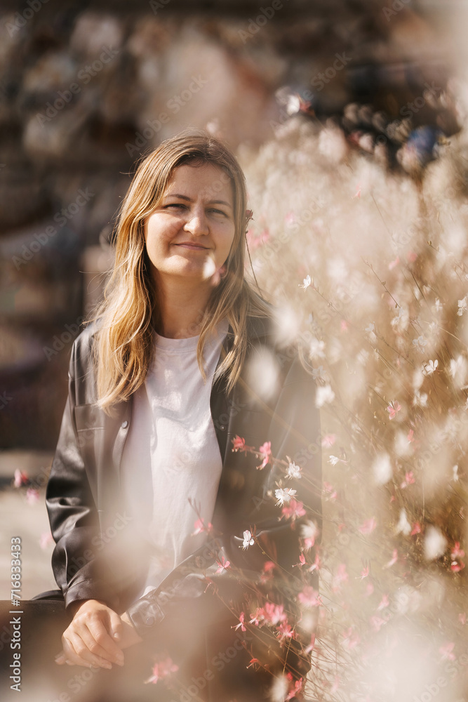 A Caucasian girl in a leather jacket on the background of spring flowers in Istanbul. a Russian girl in Turkey. a blonde woman in a black jacket A Caucasian girl in a leather jacket on the background of spring flowers in Istanbul. a Russian girl in Turkey. a blonde woman in a black jacket