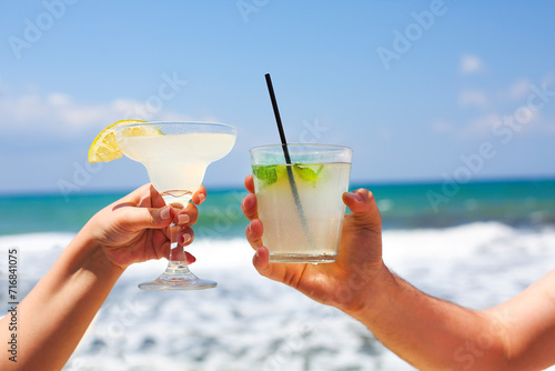 Two cocktail glasses in man and woman hands photo