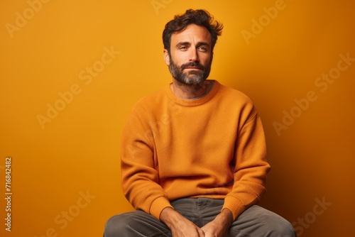 Portrait of a tender man in his 30s sporting a vintage band t-shirt against a solid color backdrop. AI Generation