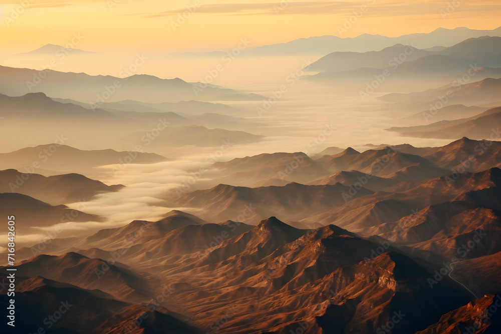 Naklejka premium Aerial view of bright foggy morning over dark hills with mountain forest trees. Beautiful scenery of wild woodland