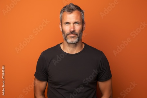Portrait of a content man in his 40s dressed in a casual t-shirt against a solid color backdrop. AI Generation
