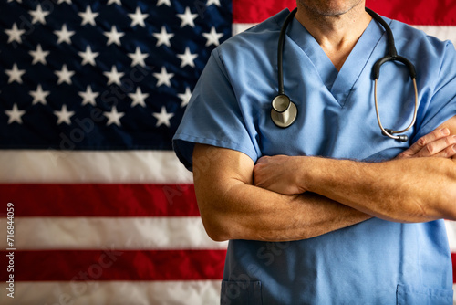 Health: Doctor With Arms Crossed In Front Of Flag