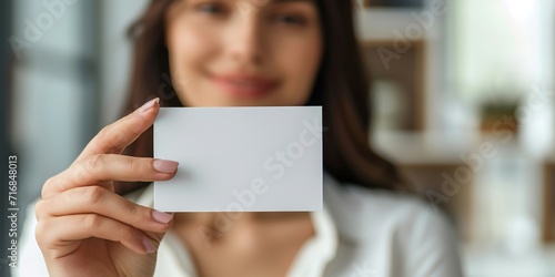 a beautiful woman holds a blank business card