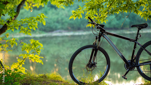 MTB bike stands on the shore, green nature background