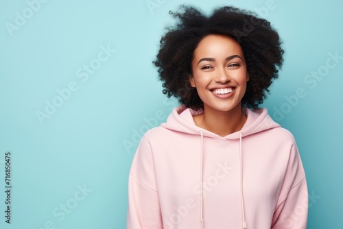 Portrait of a glad afro-american woman in her 20s wearing a zip-up fleece hoodie against a solid pastel color wall. AI Generation