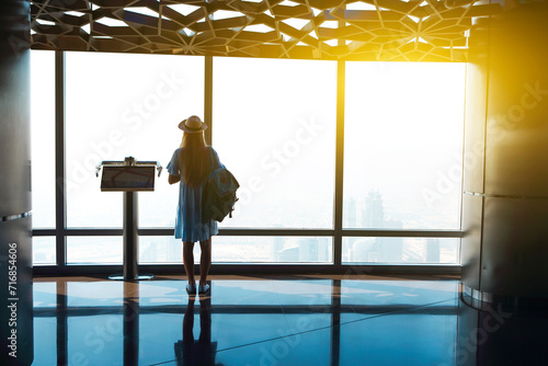 Canvas Print Silhouette of the girl tourist at window of skyscraper of the Burj Khalifa in Du