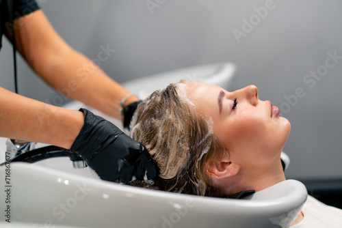 close-up of hairdresser shampooing a client's hair in a beauty salon before dyeing health treatment