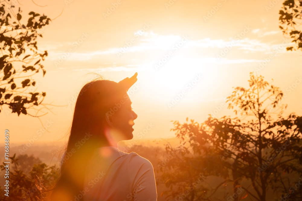 Medium shot Asian female standing against sunset in golden hour on Autumn vacation day, young cheerful happy lifestyle freedom traveling alone in nature outdoor activity, tourist woman enjoy carefree