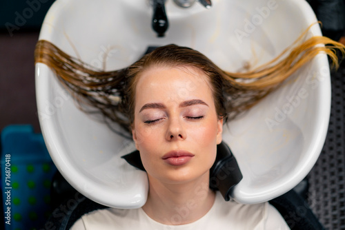 close-up of a hairdresser applying paint to a client's wet hair in a beauty salon makeover