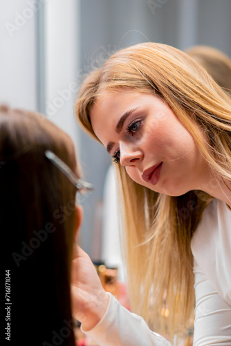 close-up of a make-up artist applying eyeshadow with a brush to a client's face in a beauty salon