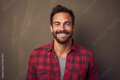 Portrait of a smiling man in his 30s dressed in a relaxed flannel shirt against a plain cyclorama studio wall. AI Generation