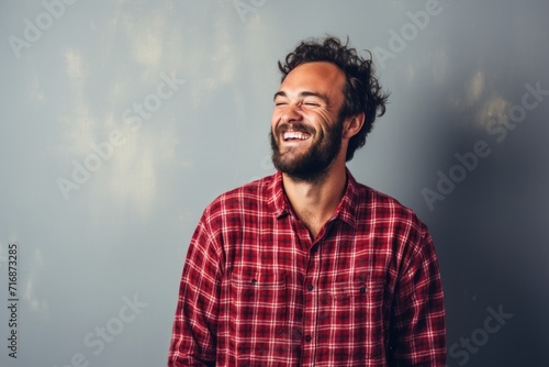 Portrait of a smiling man in his 30s dressed in a relaxed flannel shirt against a plain cyclorama studio wall. AI Generation
