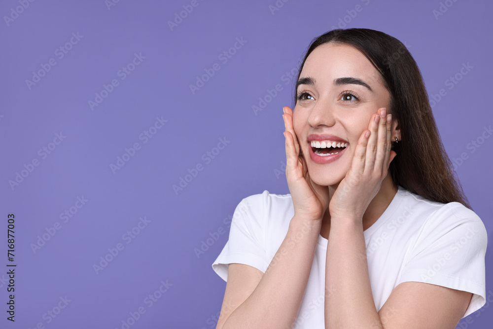 Portrait of happy surprised woman on violet background. Space for text Portrait of happy surprised woman on violet background. Space for text