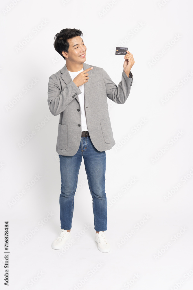 Young Asian freelancer businessman in suit showing credit card isolated on white background Young Asian freelancer businessman in suit showing credit card isolated on white background