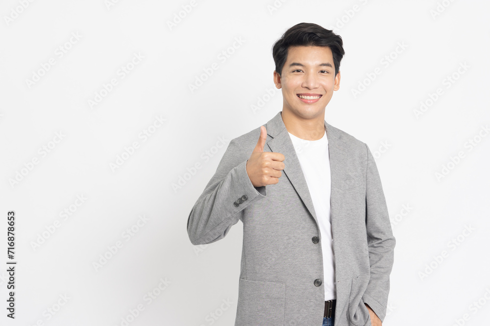 Young Asian businessman in suit showing thumbs up isolated on white background Young Asian businessman in suit showing thumbs up isolated on white background