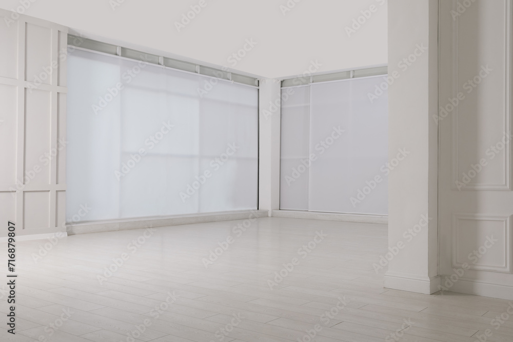 Fototapeta premium Empty room with beige walls and laminated flooring