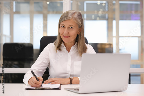 Confident woman with clipboard and laptop working in office. Lawyer, businesswoman, accountant or manager