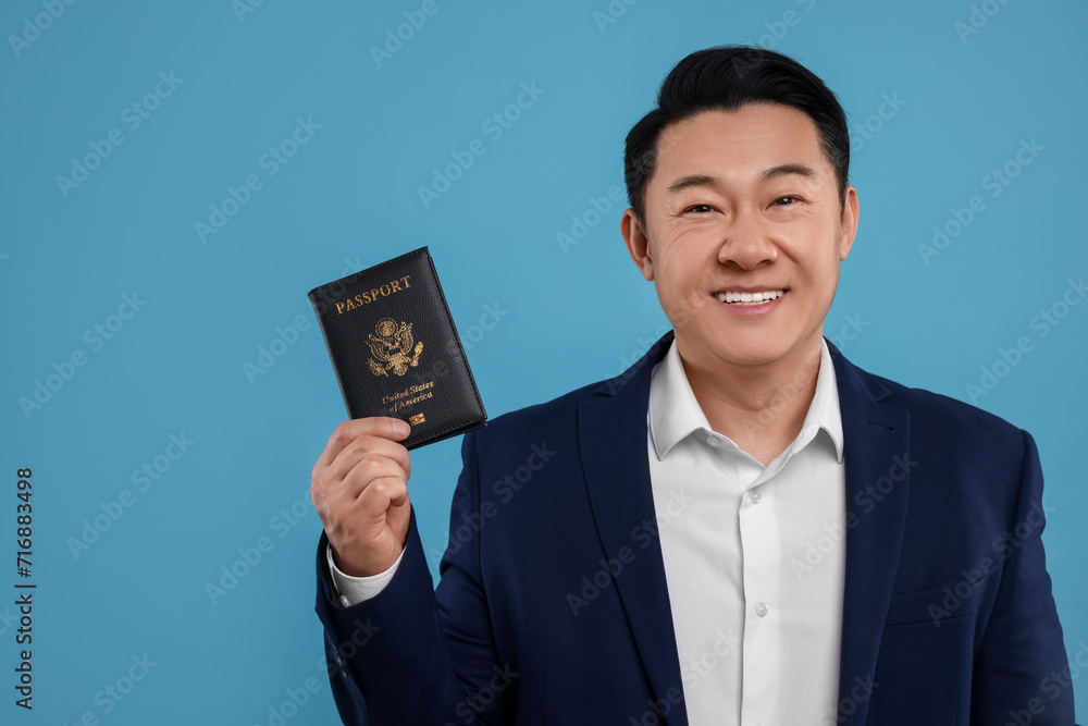 Immigration. Happy man with passport on light blue background, space for text Immigration. Happy man with passport on light blue background, space for text