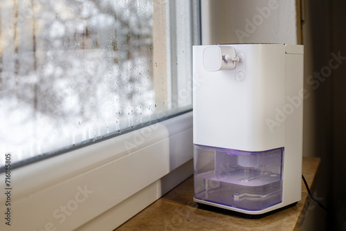 Dehumidifier, humidity indicator, air ionizer, water container works by wet window.