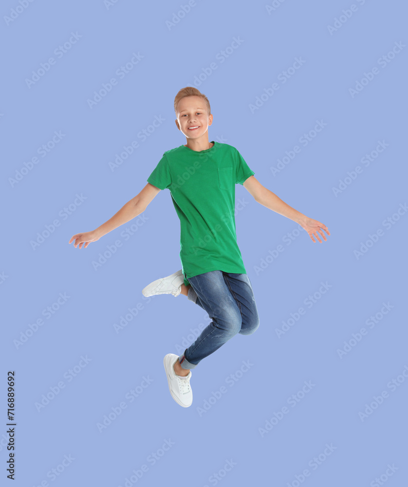 Teenage boy jumping on light blue background, full length portrait Teenage boy jumping on light blue background, full length portrait