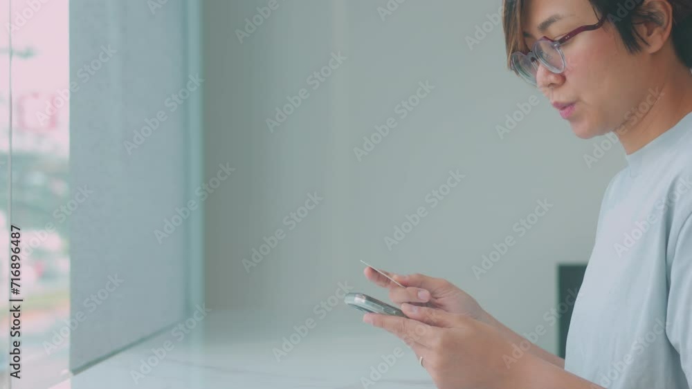 Close up face of pretty Asian woman who is using smartphone and holding credit card for online shopping, paying bill and purchasing e-commerce as urban lifestyle with happiness and enjoyment. Close up face of pretty Asian woman who is using smartphone and holding credit card for online shopping, paying bill and purchasing e-commerce as urban lifestyle with happiness and enjoyment.