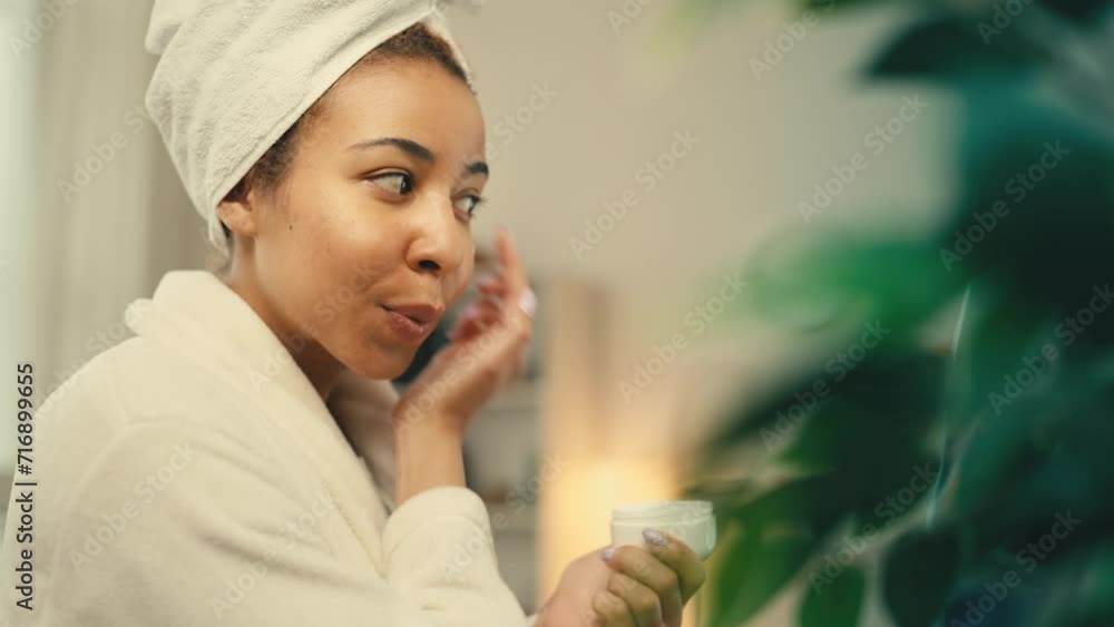 Smiling African American female applying under eye cream, beauty and skincare Smiling African American female applying under eye cream, beauty and skincare